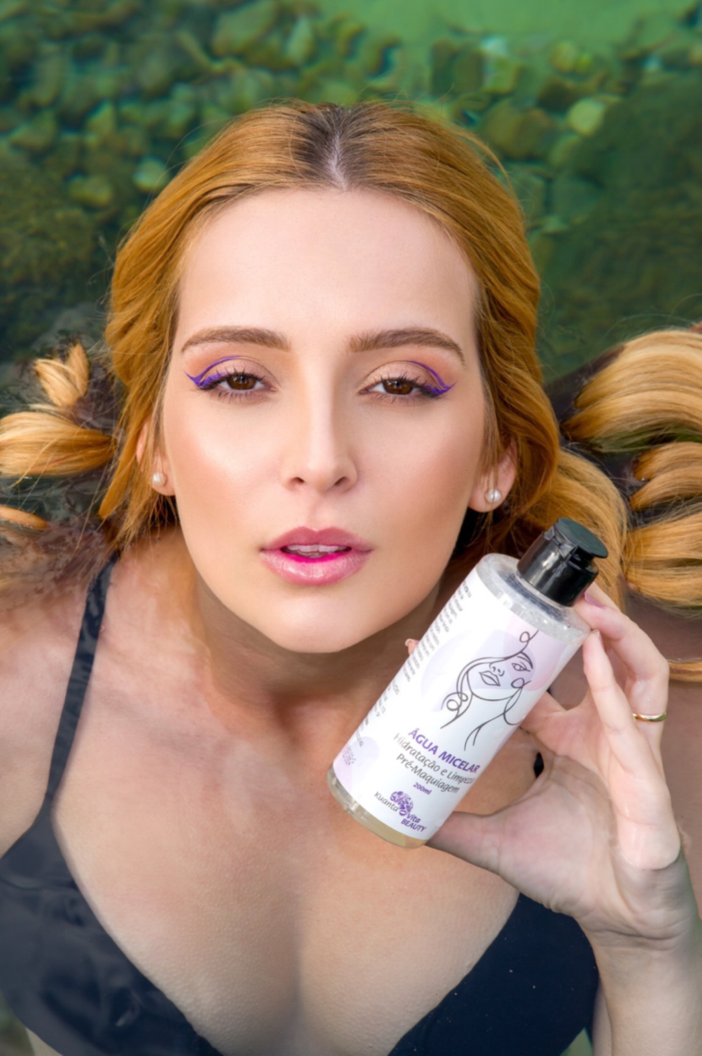 Juliana apresenta um frasco de água micelar em uma produção externa