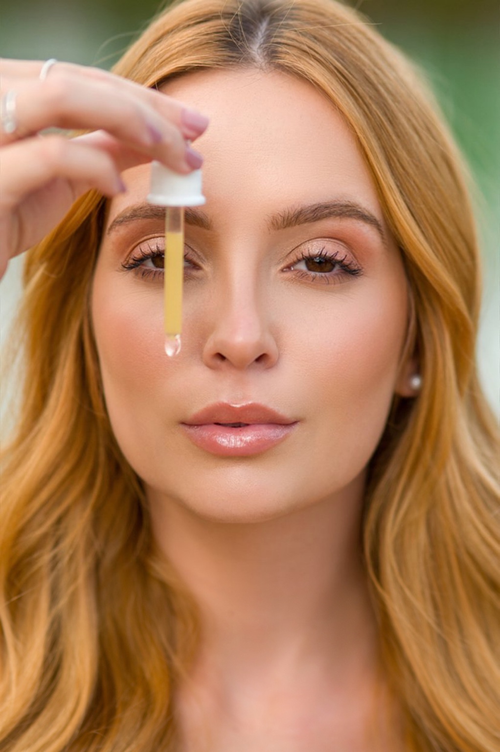 Juliana apresenta a textura de um sérum com um conta-gotas