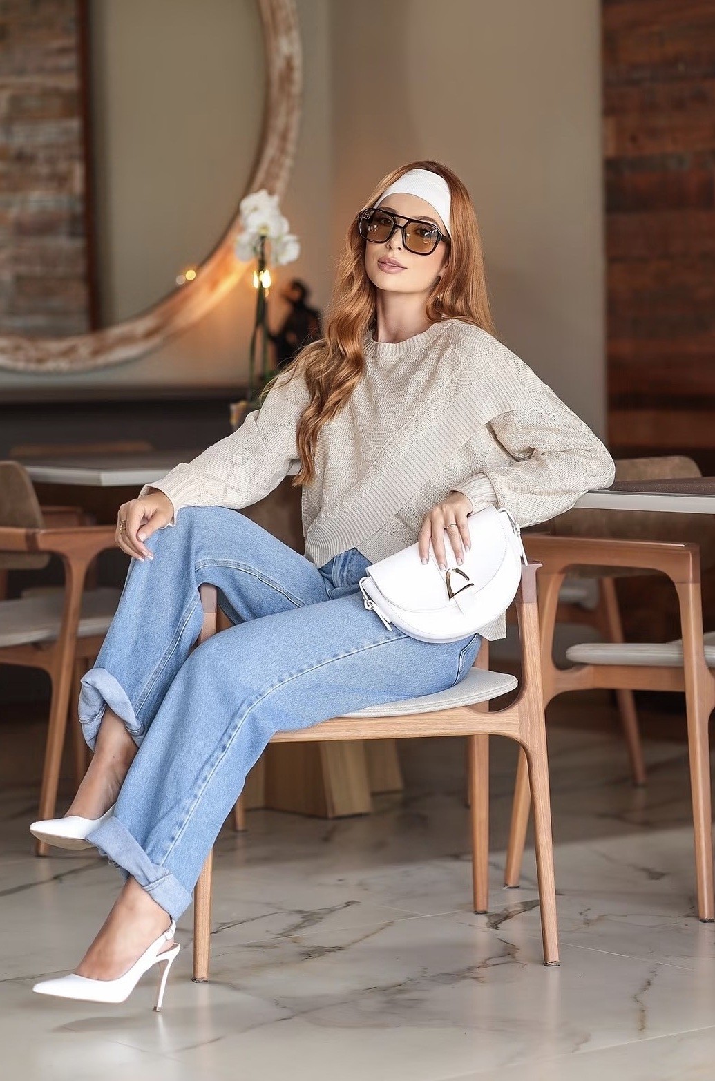 Juliana em produção externa com jeans e tricô em um café